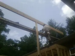Carpenter setting a ridge beam over a new addition frame — Ice Dam Removal by Roofing Brothers in Grandville