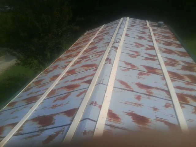 Rusted metal roof panels with new wood purlins before replacement — Storm Damage Roof Repair in Grandville by Roofing Brothers