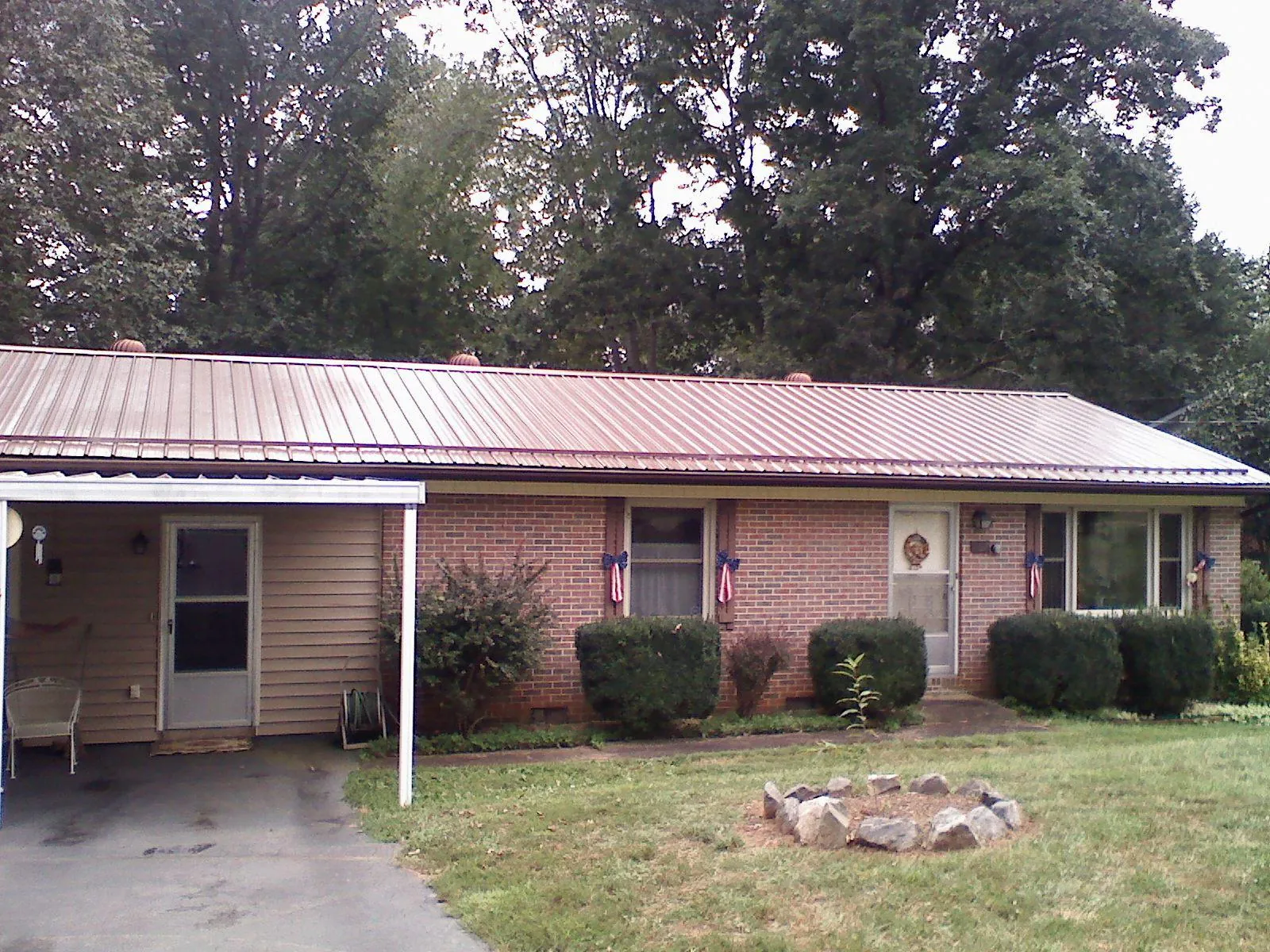 Bronze metal roof and carport on a brick ranch home — Roof Repair work by our crew in Grandville