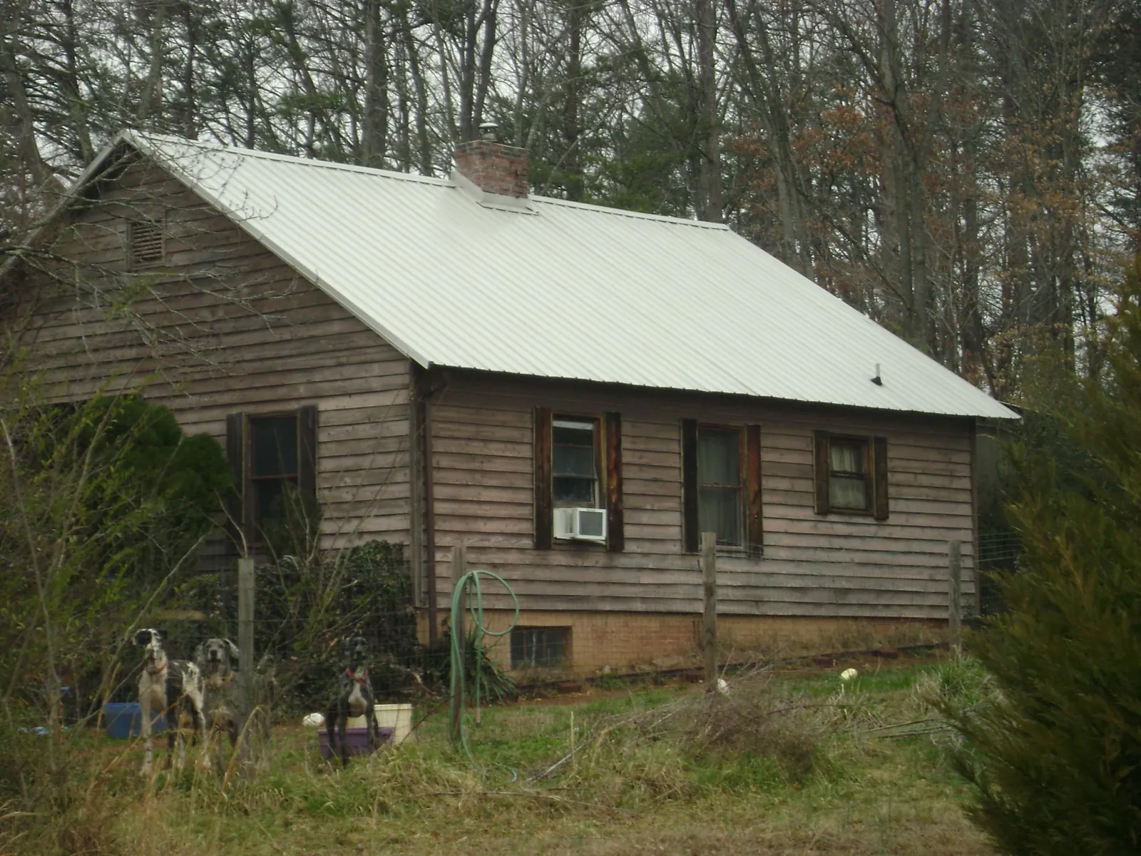White metal roof on an old wood sided farmhouse, from a Metal Roof Installation job in Grandville